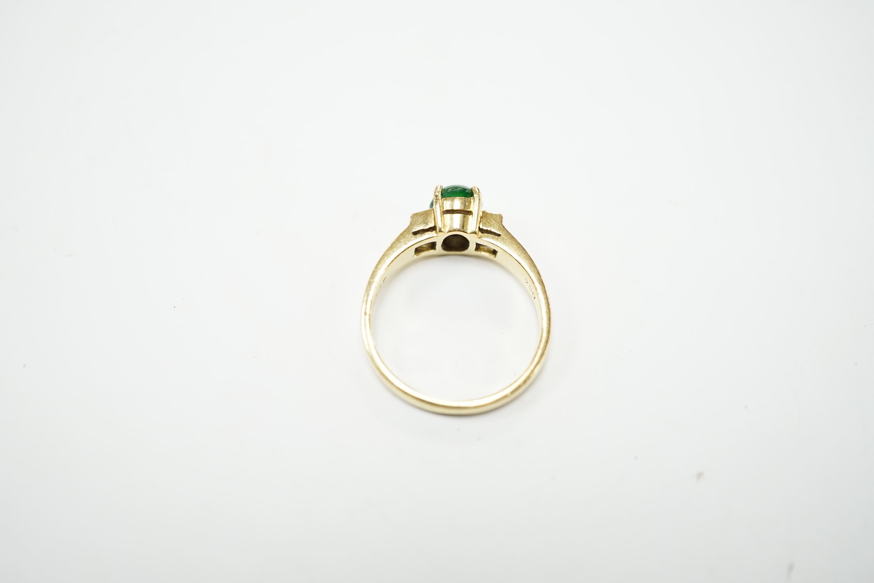 A 750 yellow metal, single stone cabochon jade and two stone baguette cut diamond set ring, size M, gross weight 4.8 grams.